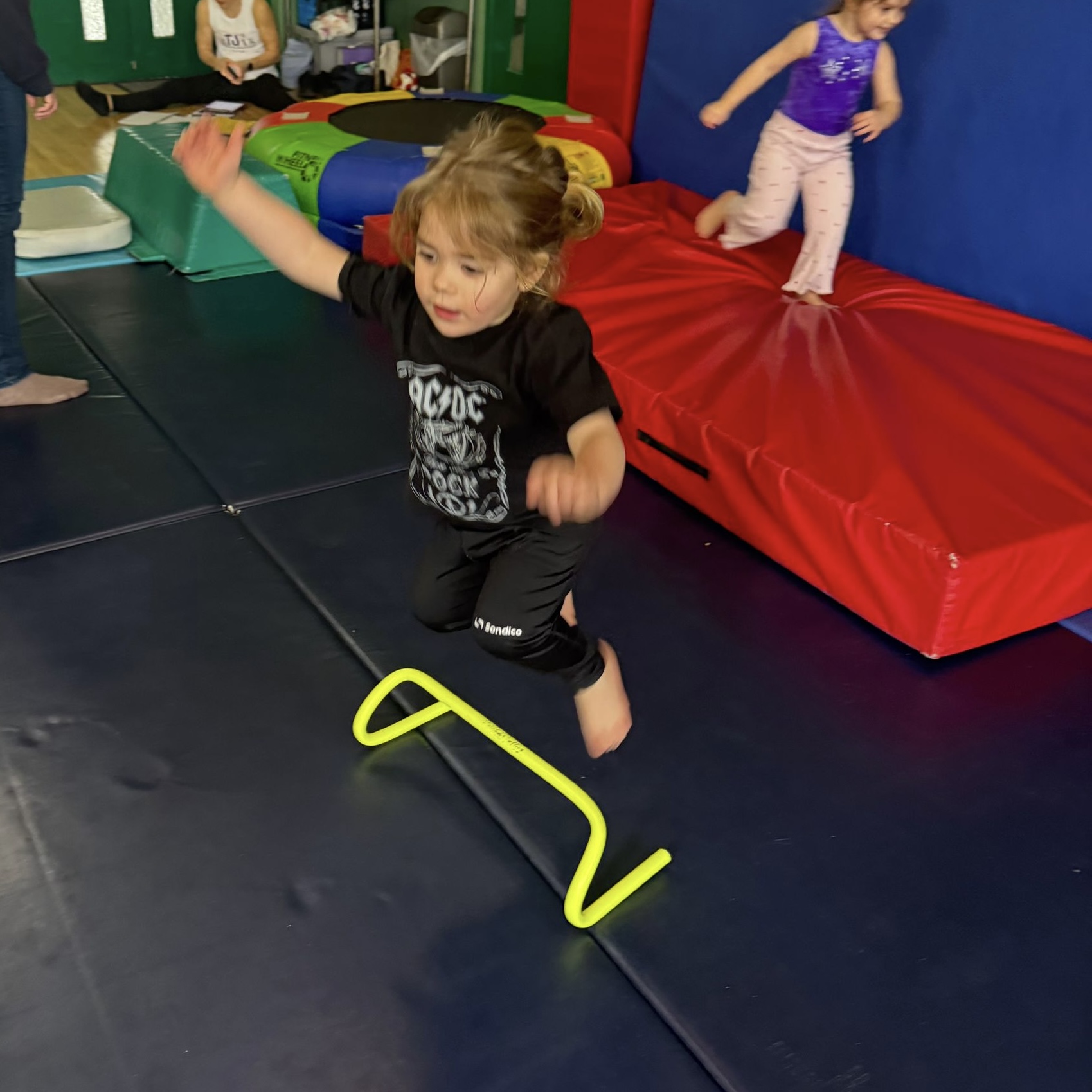 Coach supporting a young child during gymnastics practice